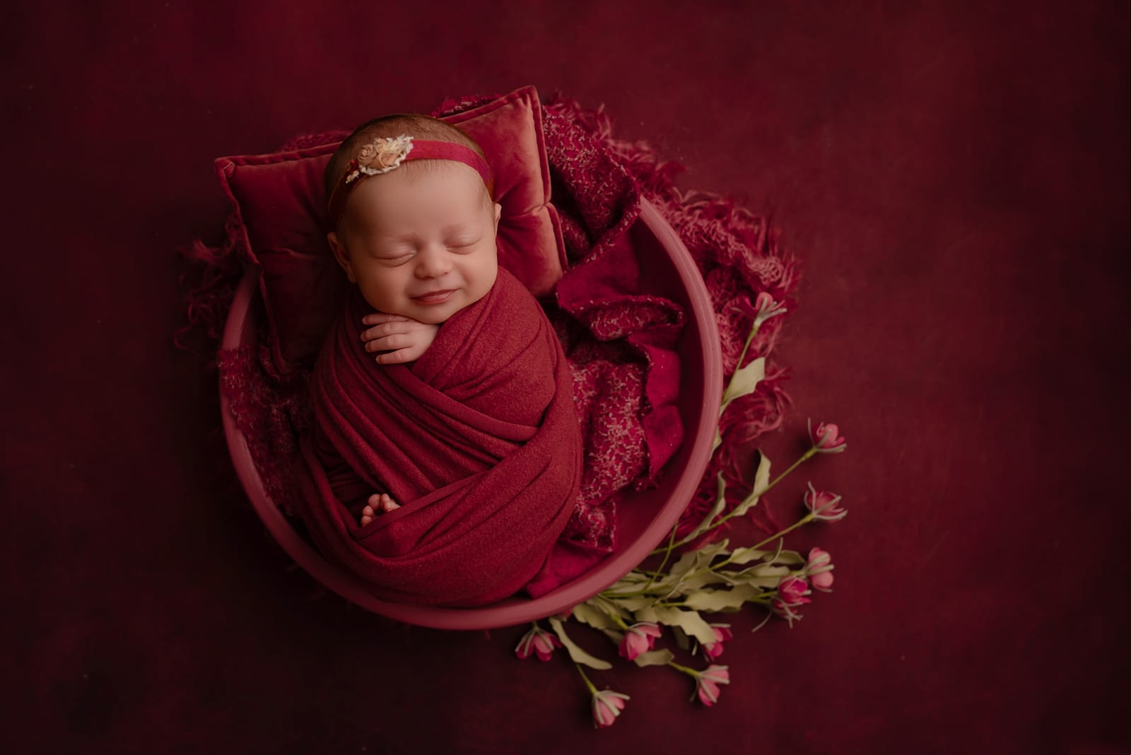 Newborn in red basket setup